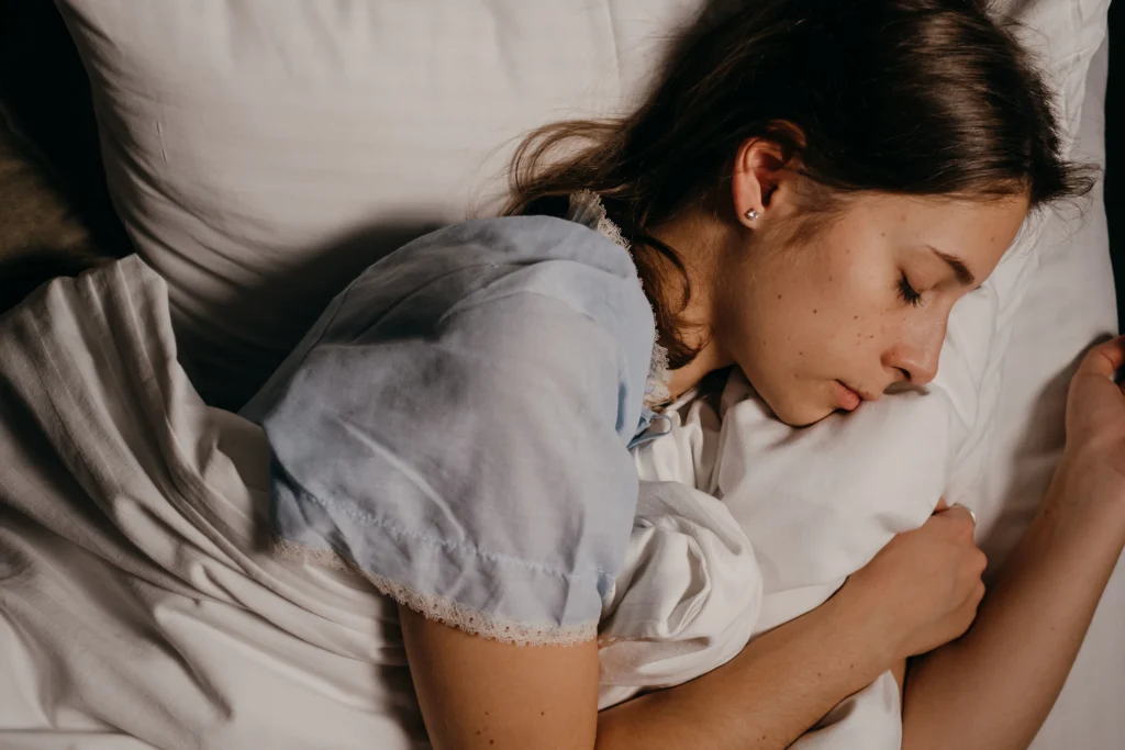 Chica acostada en la cama tomando sus horas de sueño